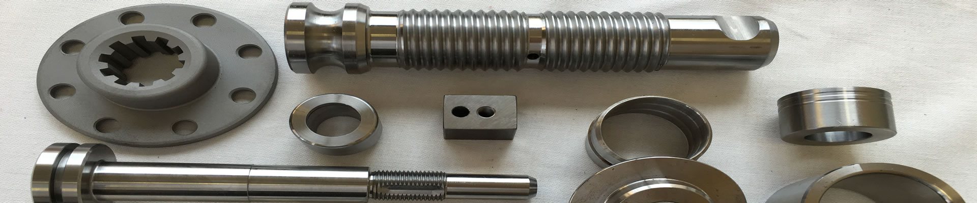 Machined parts made at Rassey: a splined flange, threaded shafts, rings and a drilled block